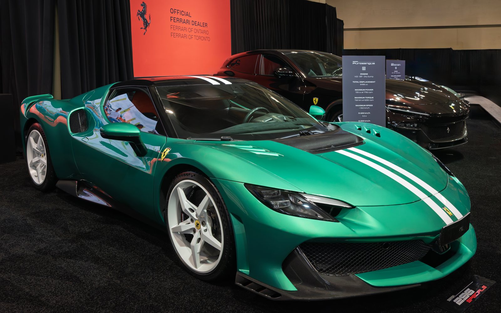 Ferrari 296 Speciale in green with twin white stripes on an indoor Ferrari display stand, front three-quarter view