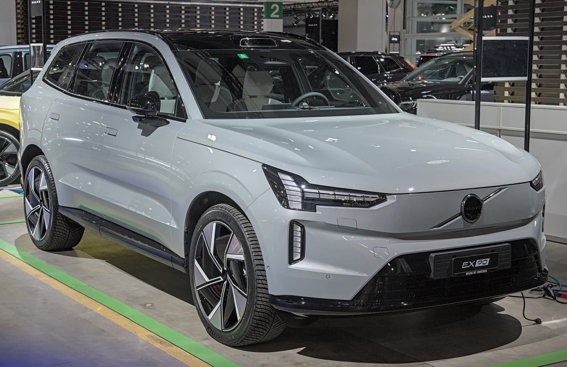 Volvo EX90 electric SUV in silver on a showroom floor